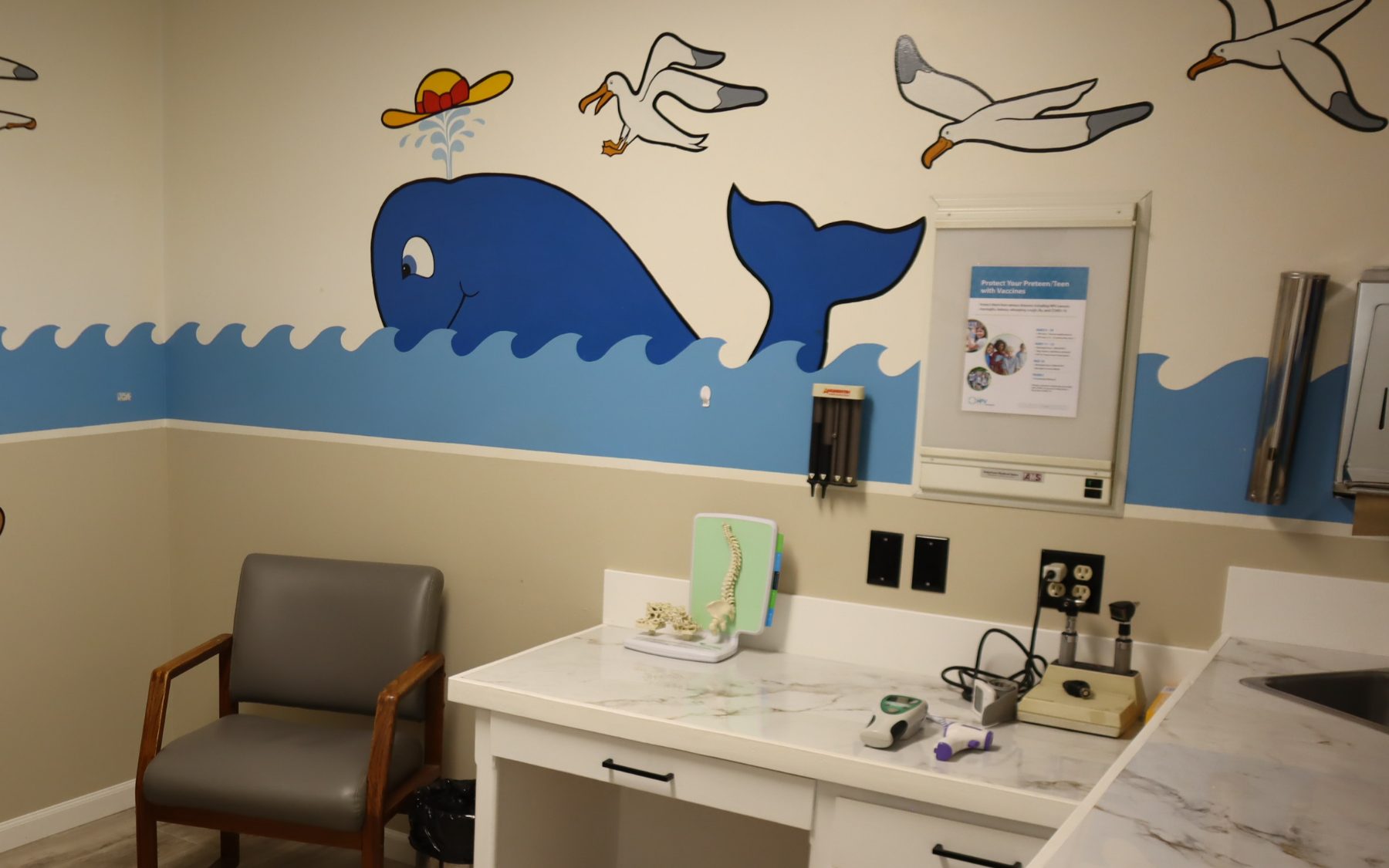 The pediatric exam room at Pine Family Practice, with its ocean mural